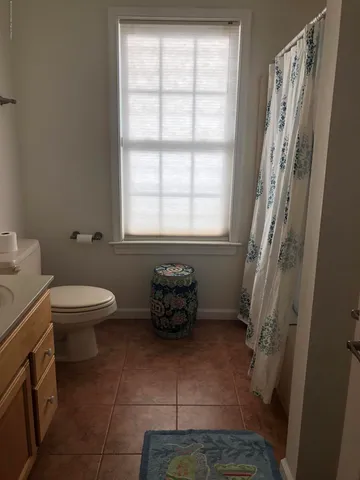 a bathroom with sink toilet and window