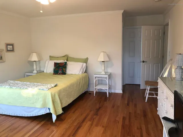 a bedroom with a bed and a flat tv screen on a dresser