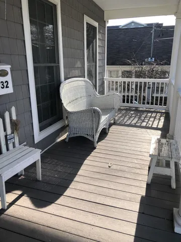 a view of a balcony with two chairs and wooden floor