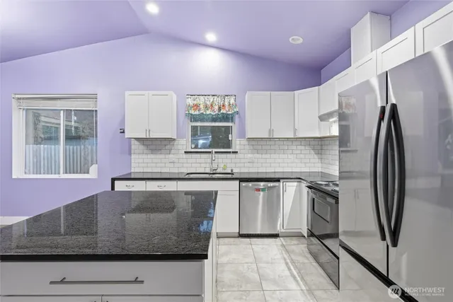 a kitchen with stainless steel appliances granite countertop a refrigerator sink and cabinets