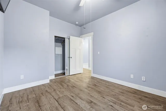 an empty room with wooden floor and closet