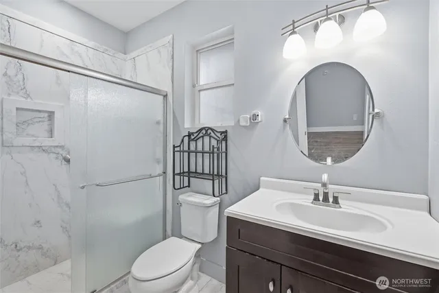 a bathroom with a toilet a sink and mirror