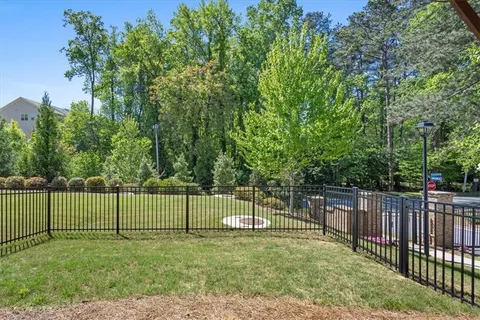 a kitchen with stainless steel appliances kitchen island granite countertop a dining table chairs and a refrigerator