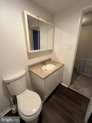 a bathroom with a granite countertop toilet sink and mirror