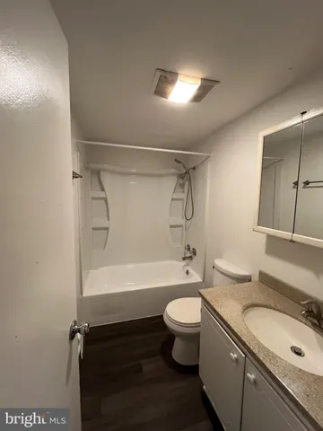 a bathroom with a granite countertop toilet sink and mirror or bathtub