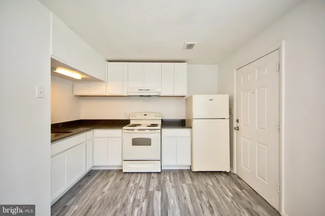 a kitchen with white cabinets and white appliances