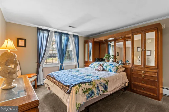 a bedroom with a bed and large windows