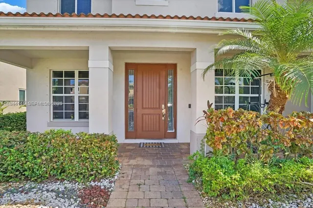 front view of a house with a window and potted plants