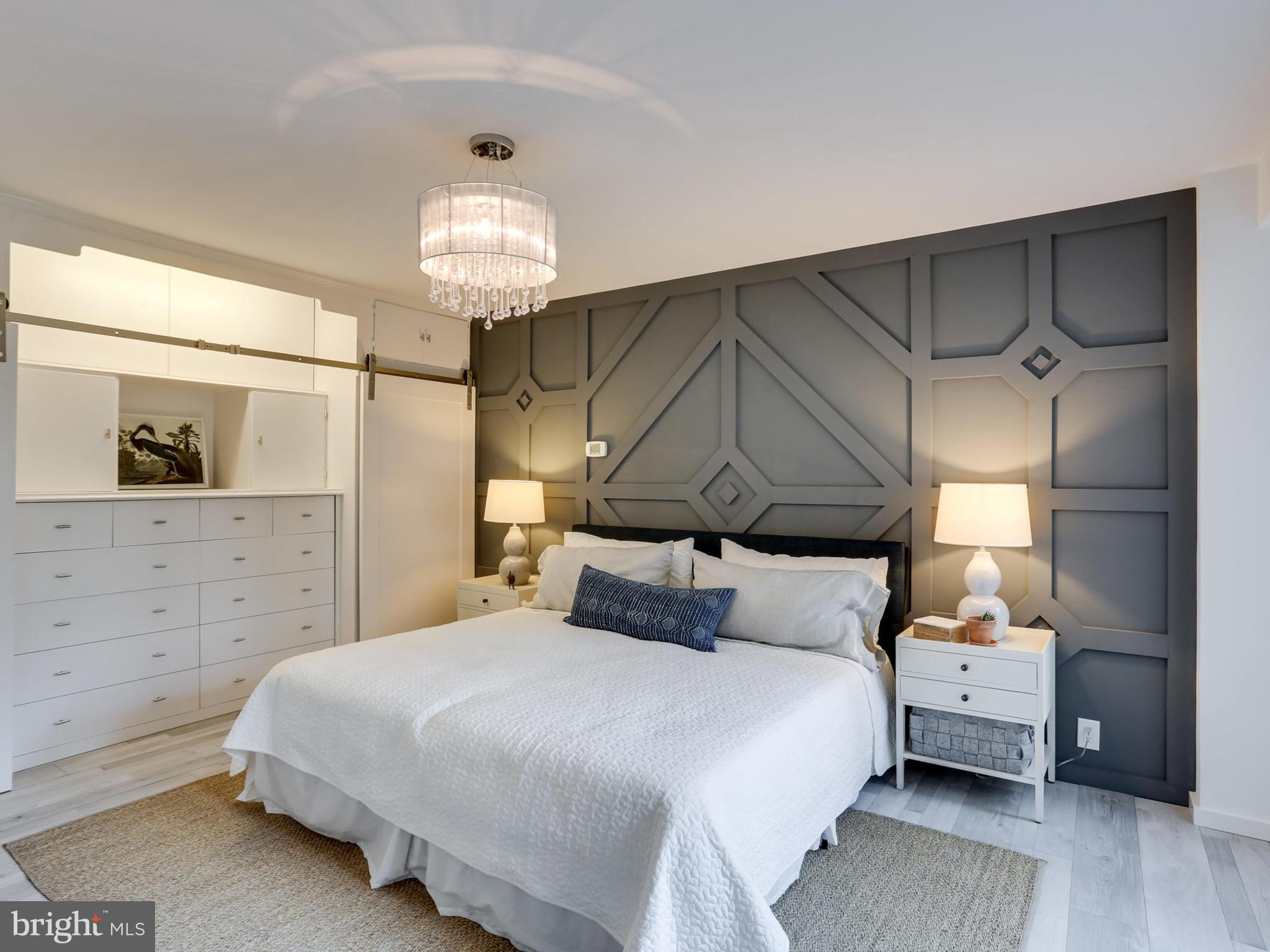 4201 Cathedral Avenue Northwest, Unit 703W Washington, DC 20016 - Photo 12 of 20 a bedroom with a bed and a chandelier