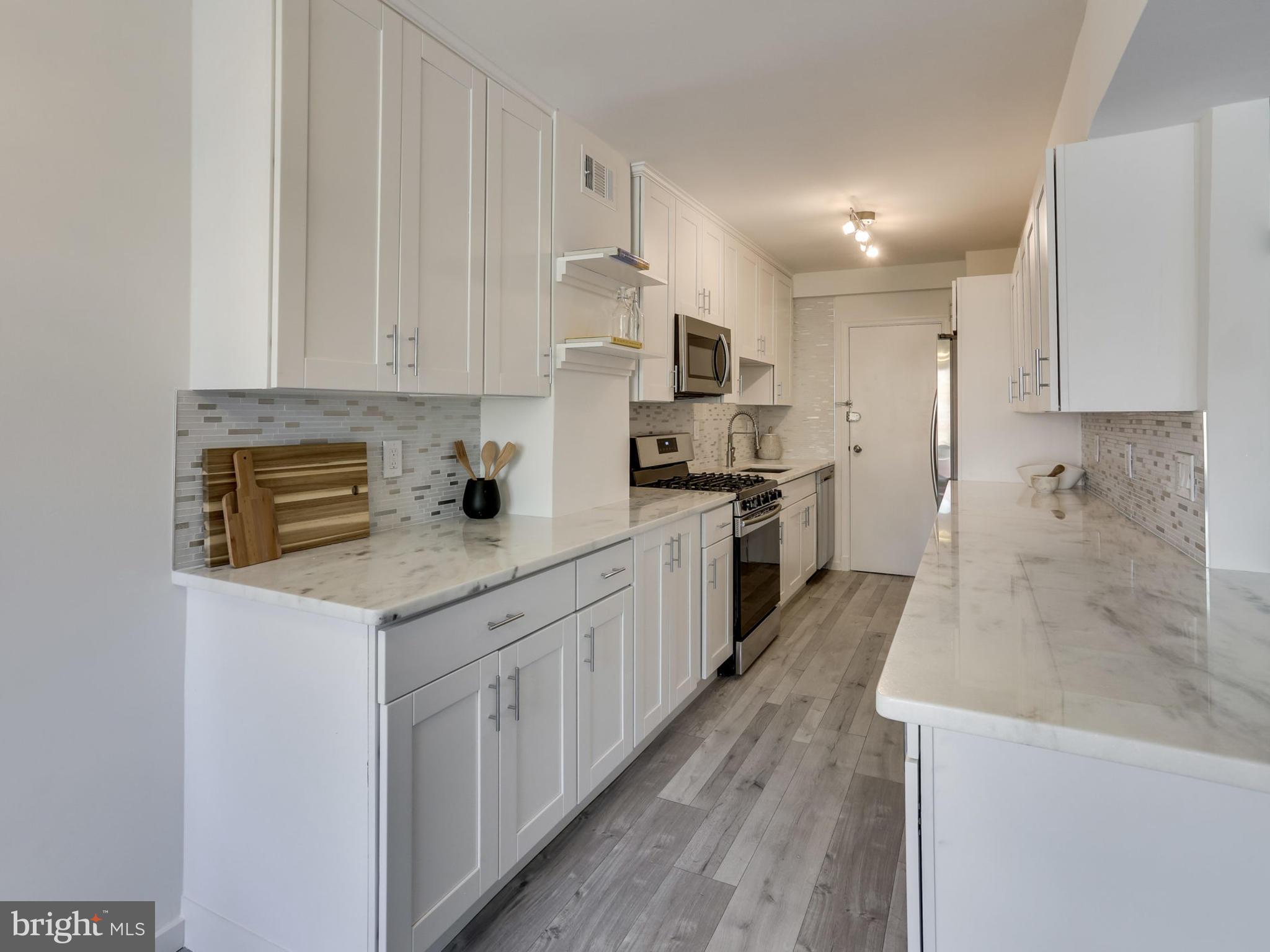 4201 Cathedral Avenue Northwest, Unit 703W Washington, DC 20016 - Photo 7 of 20 a kitchen with stainless steel appliances granite countertop a sink stove and cabinets