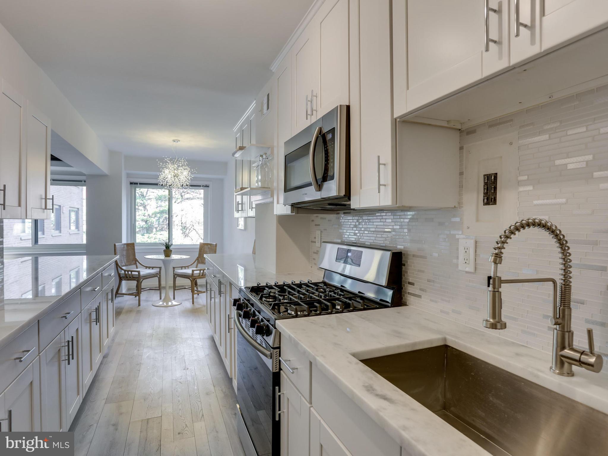 4201 Cathedral Avenue Northwest, Unit 703W Washington, DC 20016 - Photo 9 of 20 a kitchen with stainless steel appliances granite countertop a sink stove and cabinets