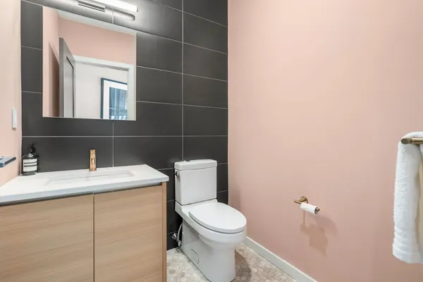a bathroom with a toilet sink vanity and mirror
