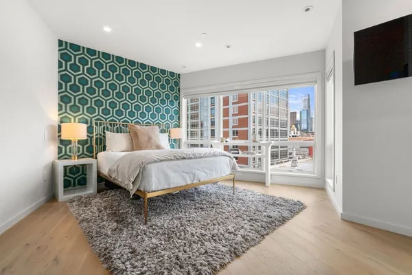 a bed sitting in a spacious bedroom next to a window