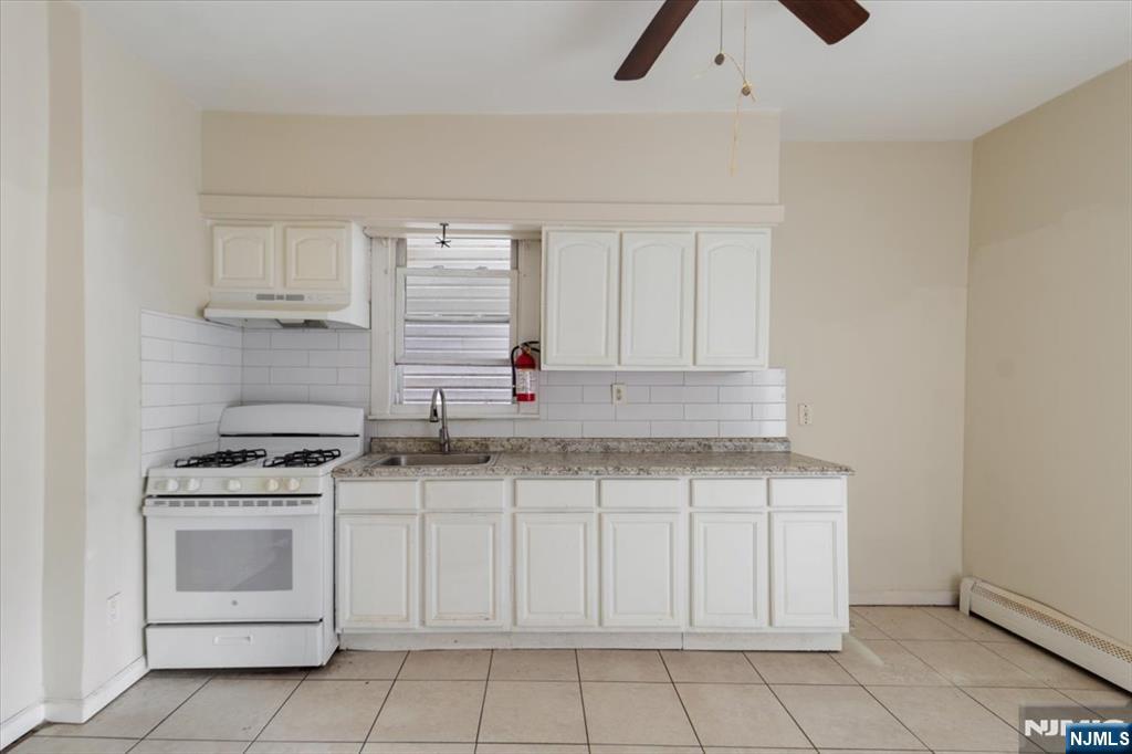 422 Jelliff Avenue, Unit 1 Newark, NJ 07112 - Photo 12 of 14 a kitchen with white cabinets and white appliances