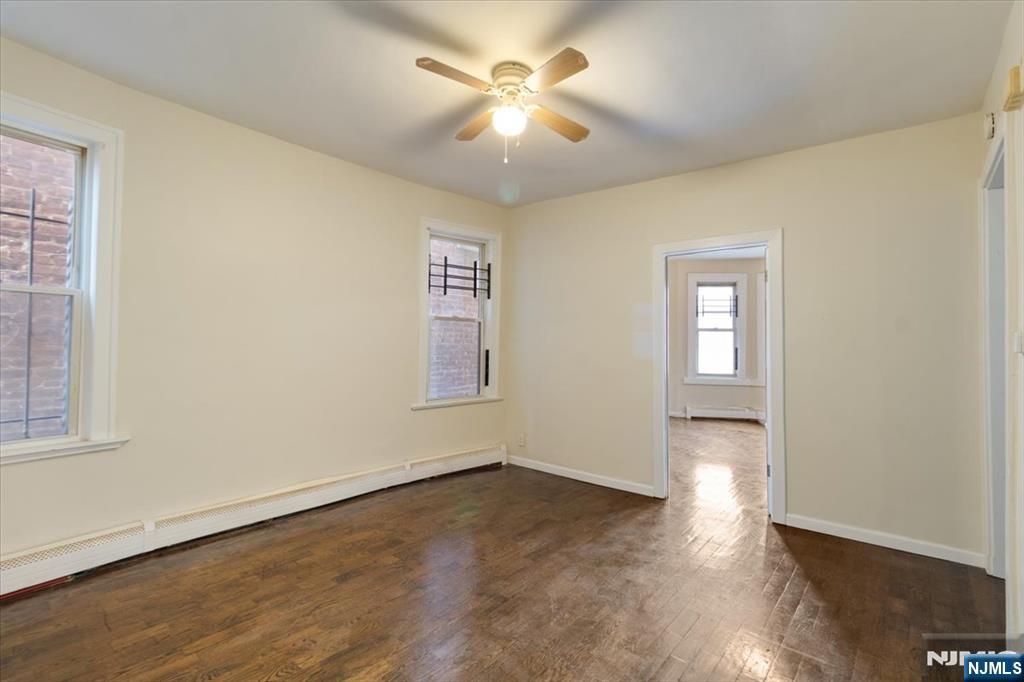 422 Jelliff Avenue, Unit 1 Newark, NJ 07112 - Photo 6 of 14 wooden floor in an empty room with a window
