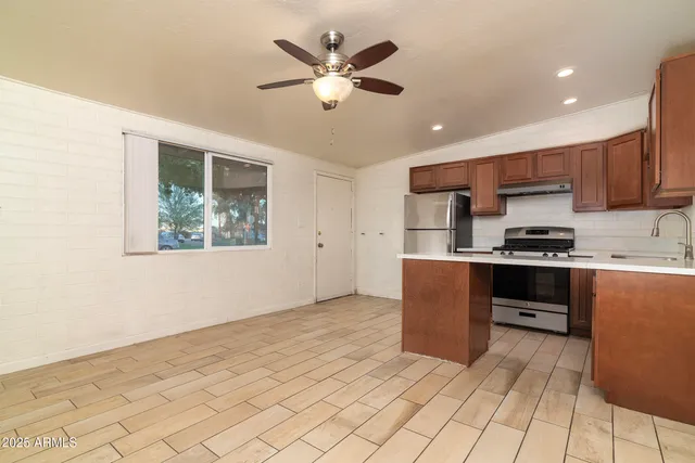 a kitchen with kitchen island white cabinets and stainless steel appliances