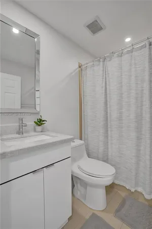a view of a kitchen with a refrigerator and a stove top oven