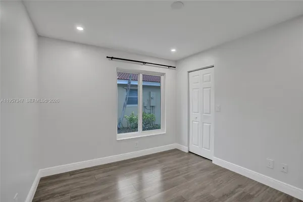 a kitchen with granite countertop white cabinets and stainless steel appliances