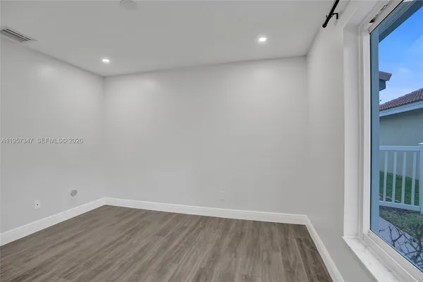 a view of an empty room with wooden floor
