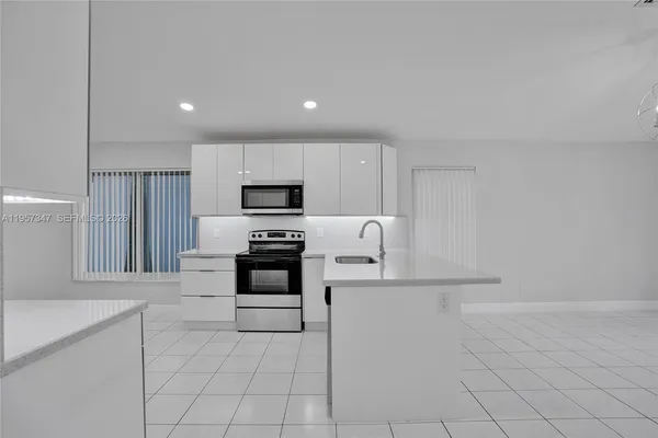 a front view of a house with a yard and palm trees