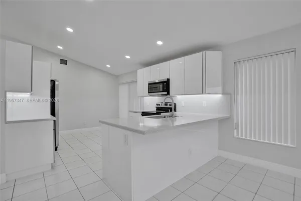 a front view of a house with a garden and trees