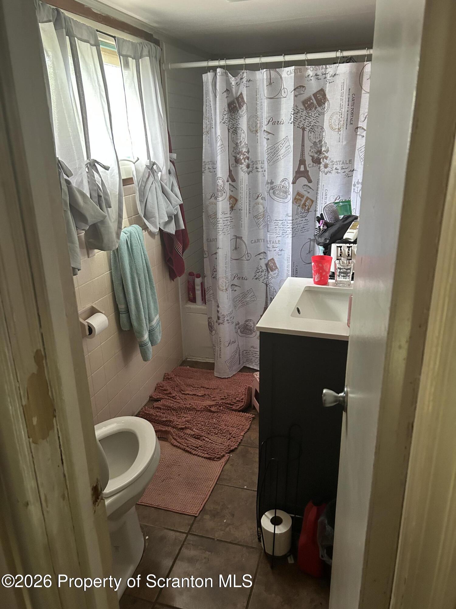 63 Shannon Street Simpson, PA 18407 - Photo 14 of 18 a bathroom with a toilet and a shower curtain