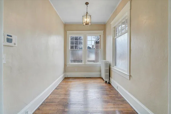 a empty room with wooden floor and windows