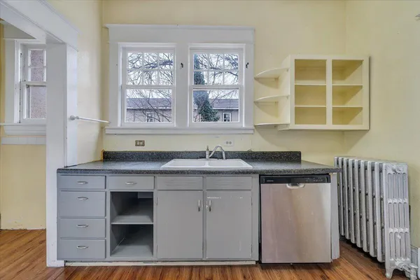 a kitchen with wooden floors and white cabinets
