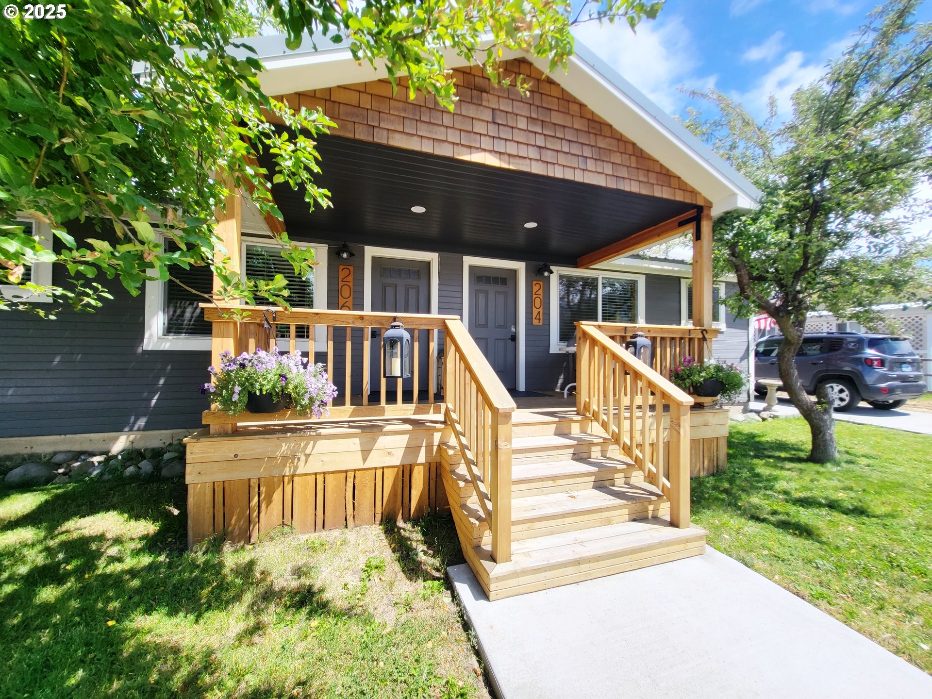 a view of a house with wooden deck front of house