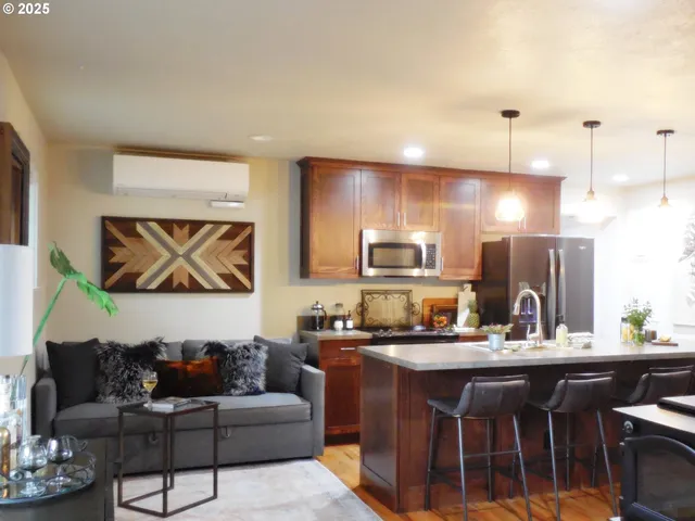 a living room with stainless steel appliances kitchen island granite countertop furniture and a view of kitchen