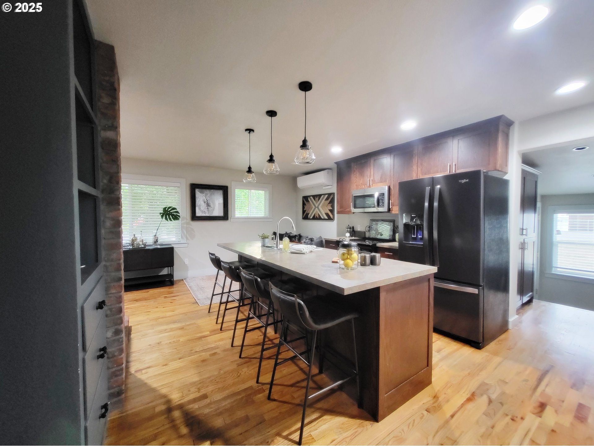 204 North Russell Street Joseph, OR 97846 - Photo 17 of 46 a kitchen with stainless steel appliances kitchen island granite countertop a refrigerator a stove a sink dishwasher and a dining table with wooden floor