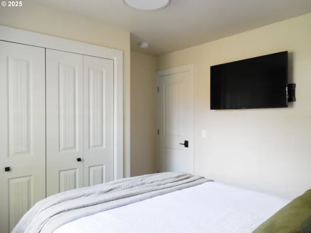 a bedroom with a bed and a flat screen tv