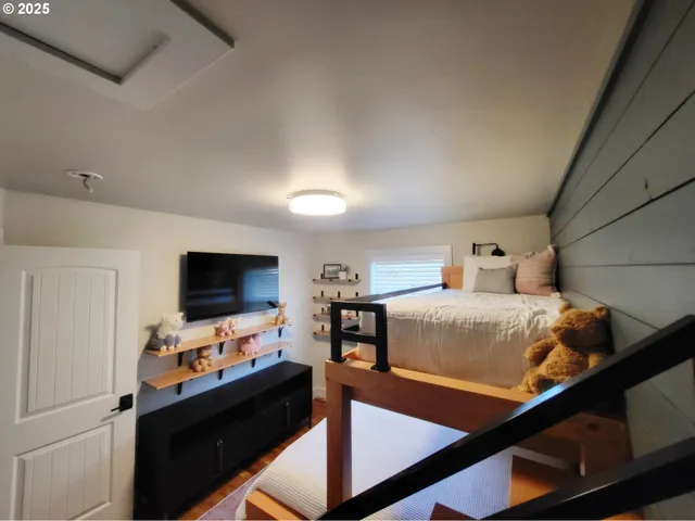 a bedroom with a bed and a flat screen tv