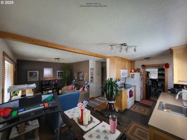 a kitchen with stainless steel appliances granite countertop a sink a stove cabinets counter space and two windows