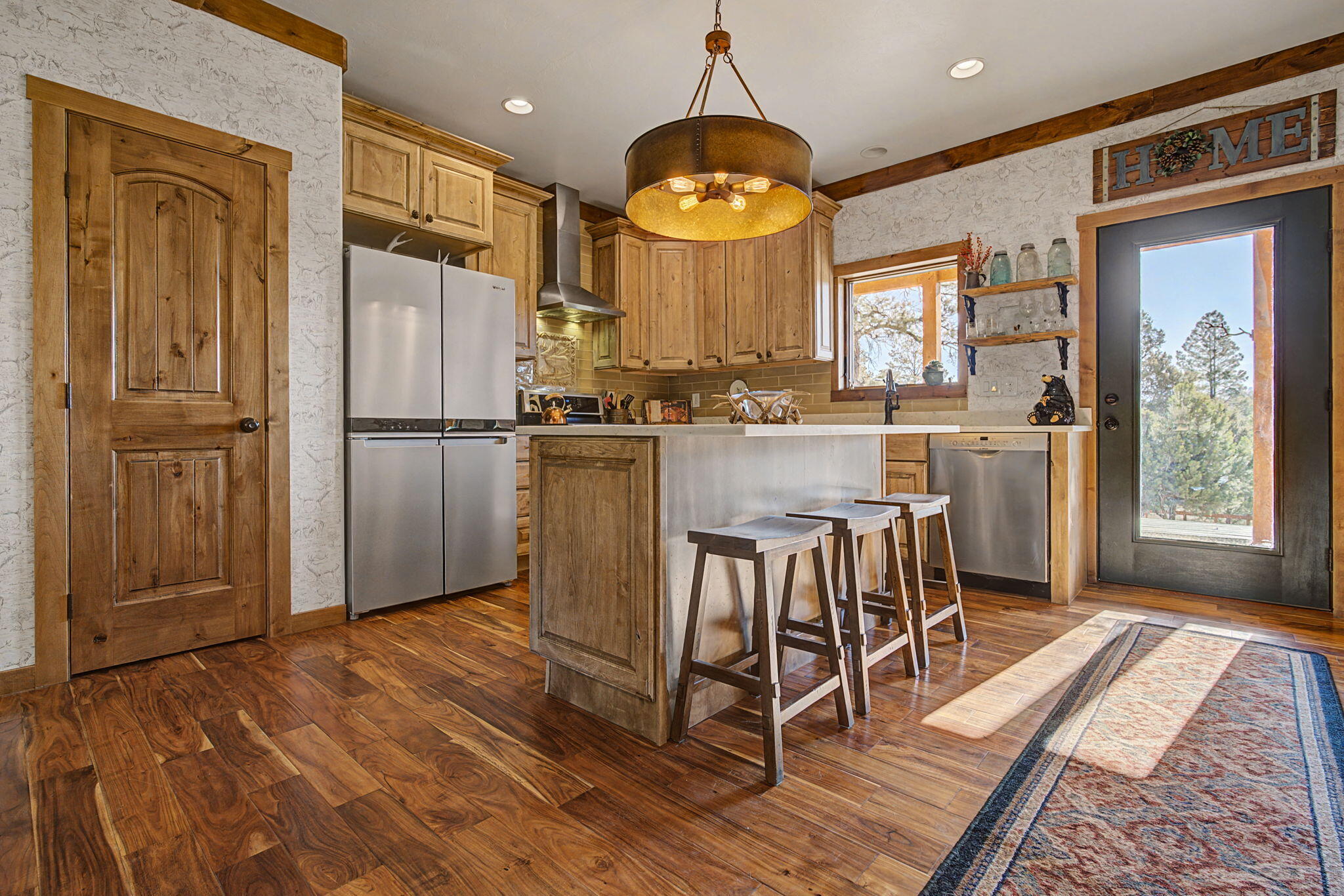 213 Big Canyon Point Ridgway, CO 81432 - Photo 7 of 41 a kitchen with stainless steel appliances granite countertop a refrigerator a oven a sink a dining table and chairs with wooden floor