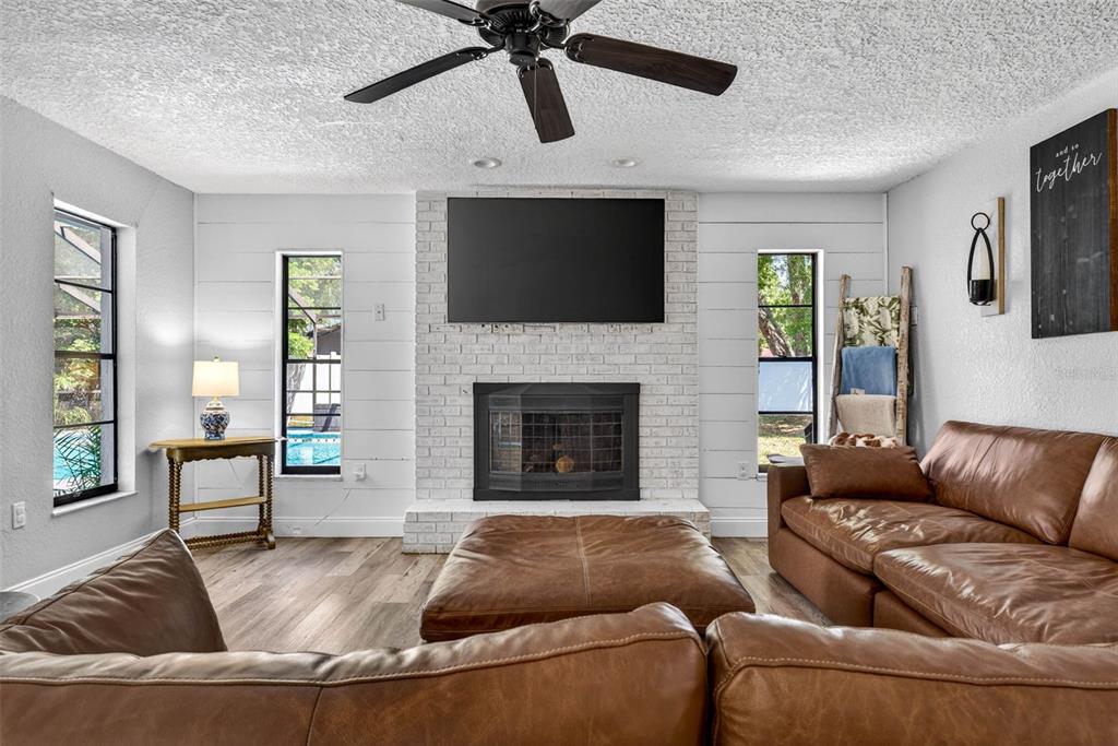 9043 Mc Cormick Street Spring Hill, FL 34608 - Photo 20 of 47 a living room with furniture and a fireplace