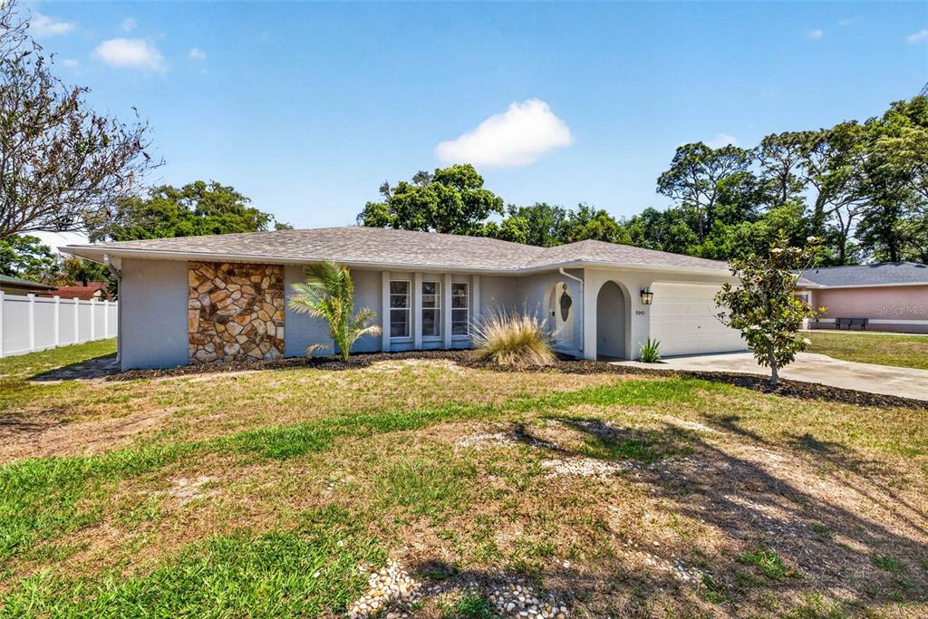 9043 Mc Cormick Street Spring Hill, FL 34608 - Photo 3 of 47 a front view of a house with garden