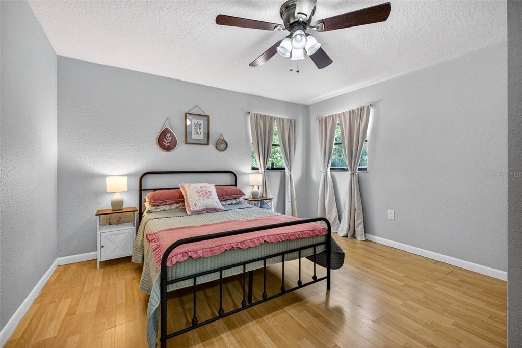 9043 Mc Cormick Street Spring Hill, FL 34608 - Photo 32 of 47 a bedroom with a bed and a chandelier