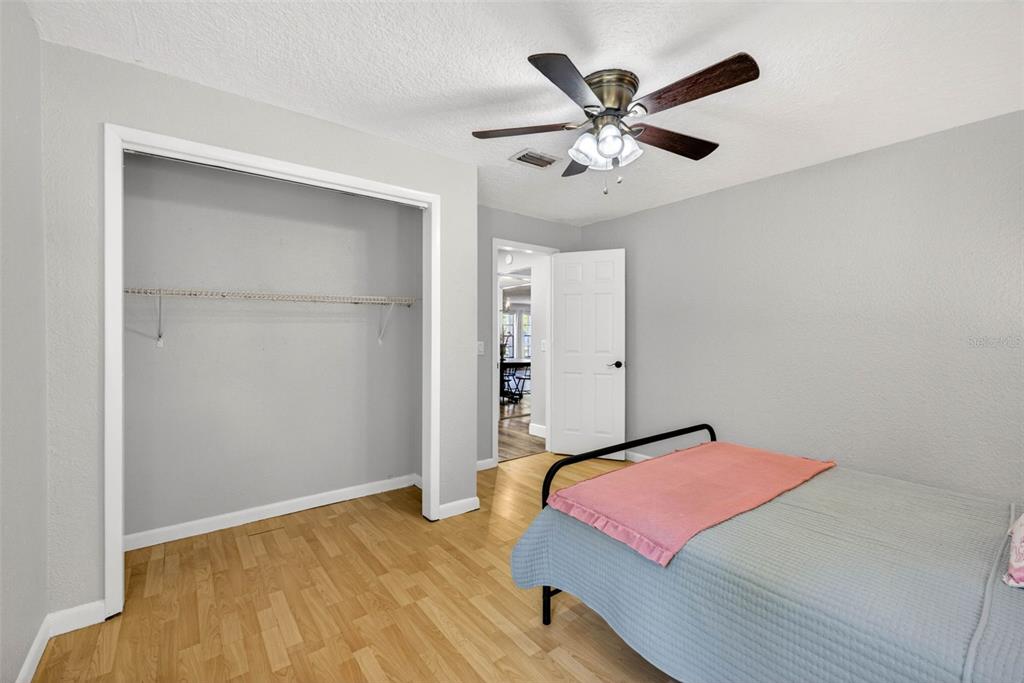 9043 Mc Cormick Street Spring Hill, FL 34608 - Photo 33 of 47 a bedroom with a large bed and a ceiling fan