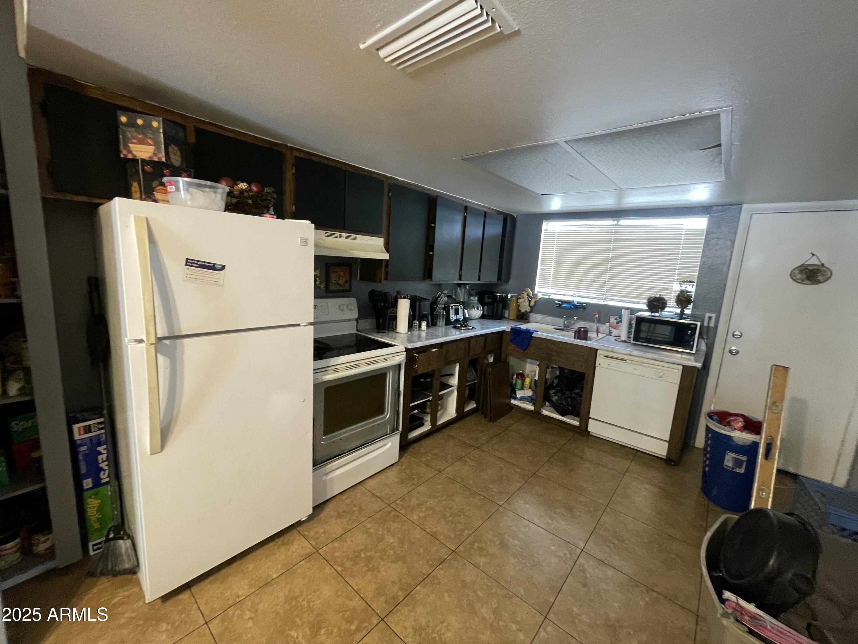 3364 West Harmont Drive Phoenix, AZ 85051 - Photo 19 of 39 a kitchen with a refrigerator a stove a sink a washer and dryer