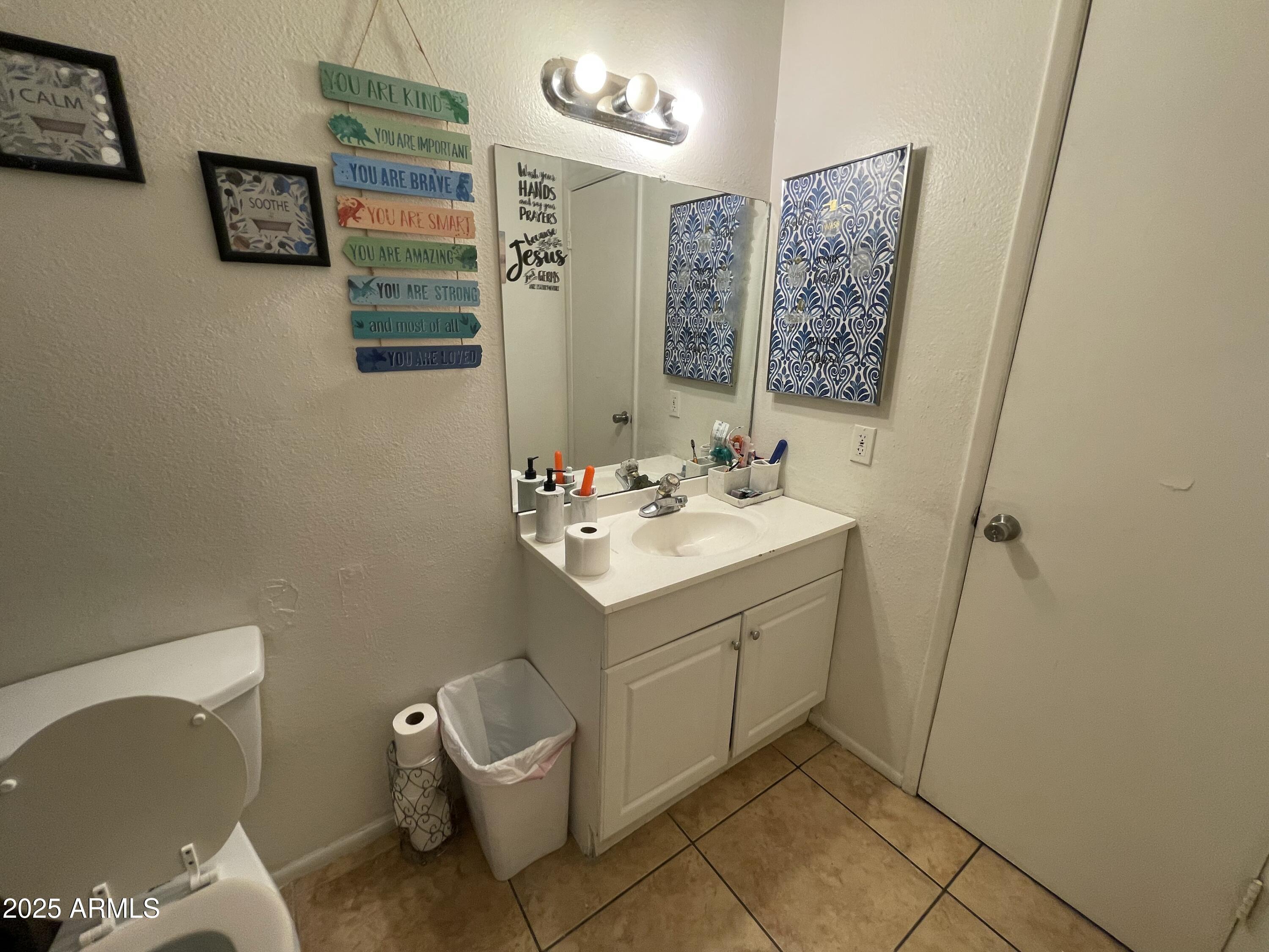 3364 West Harmont Drive Phoenix, AZ 85051 - Photo 29 of 39 a bathroom with a sink mirror and toilet