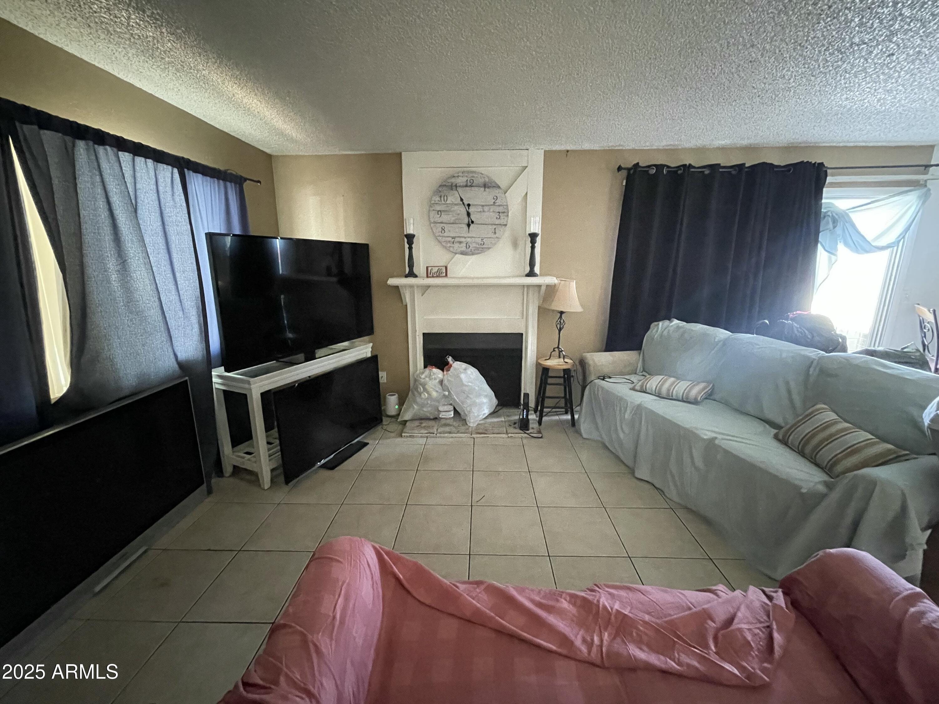3364 West Harmont Drive Phoenix, AZ 85051 - Photo 7 of 39 a living room with furniture a fireplace and a flat screen tv