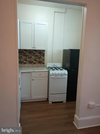 a utility room with wooden floor washer and dryer