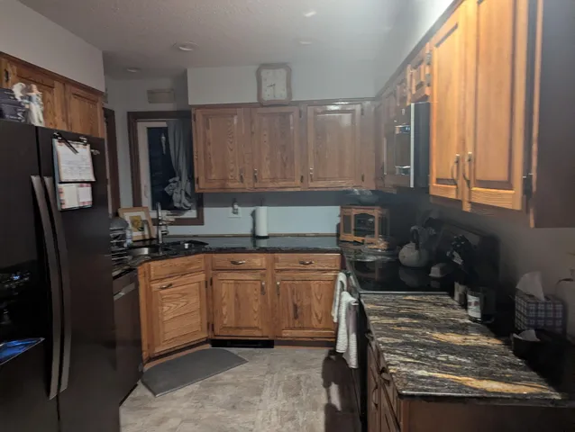 a kitchen with stainless steel appliances granite countertop a stove a sink and a refrigerator