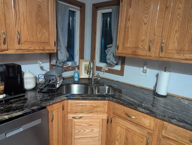 a kitchen with granite countertop stainless steel appliances a sink and cabinets