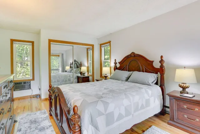 a spacious bedroom with a bed and wooden floor