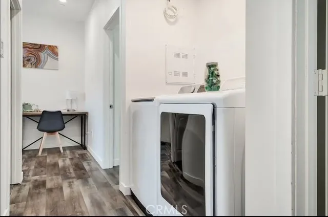 a bedroom with a bed a couch and a flat tv screen on the dresser