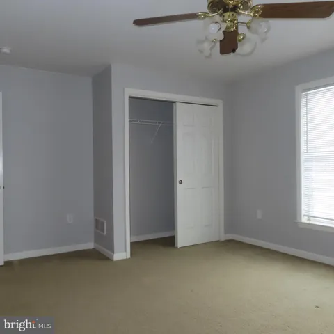 an empty room with a chandelier fan