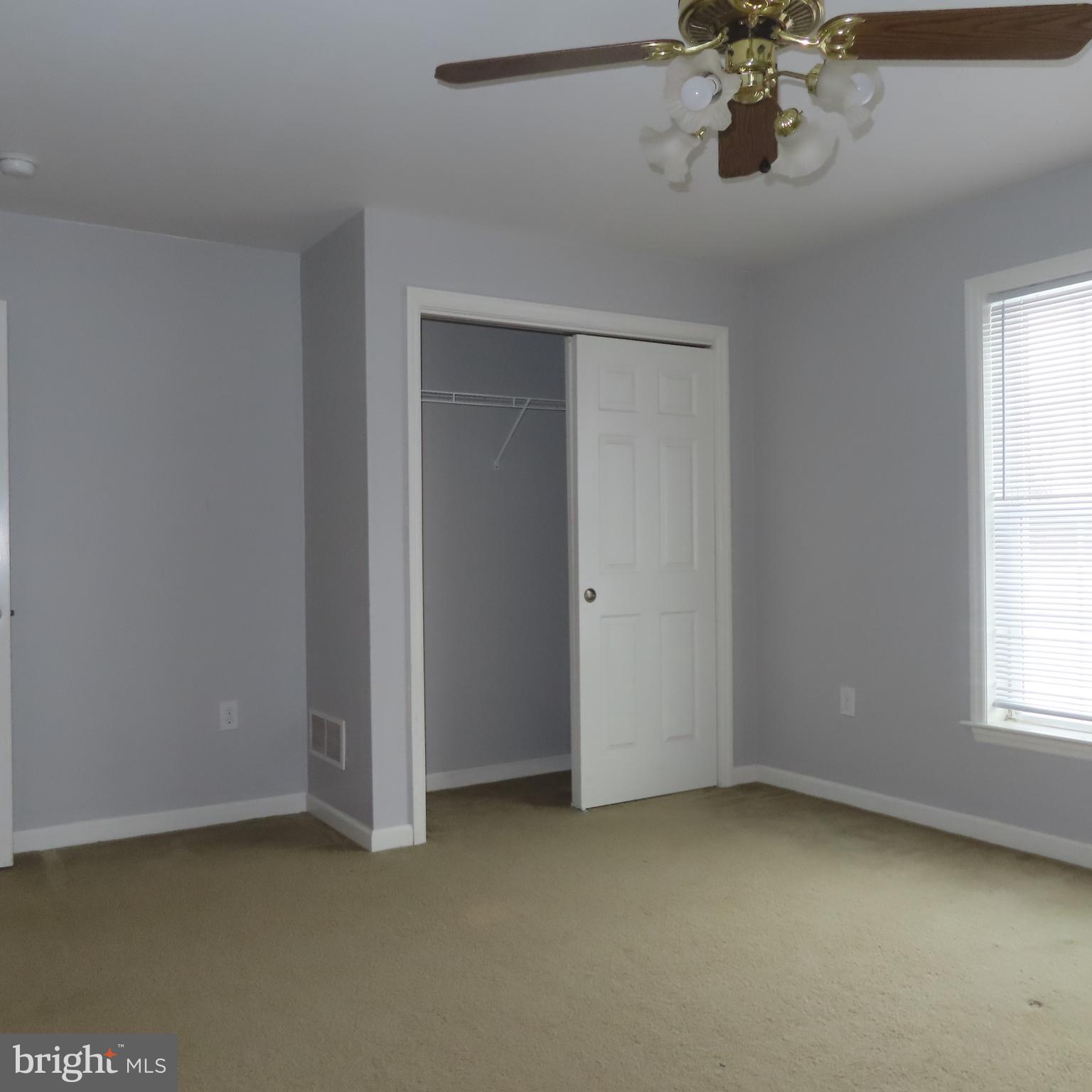 5237 Rolling Road, Unit H Chambersburg, PA 17202 - Photo 29 of 36 an empty room with a chandelier fan and windows