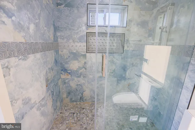 an empty room with wooden floor cabinet and windows